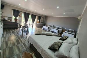 a bedroom with two beds and a kitchen with a table at Tehillah Guesthouse in Upington