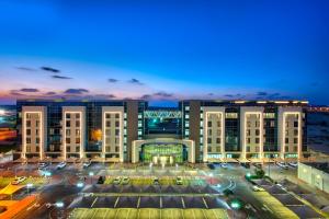 a view of a large building at night at Remal Hotel in Ruwais