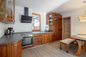 a kitchen with wooden cabinets and a table at Old Mill House in Bohinj