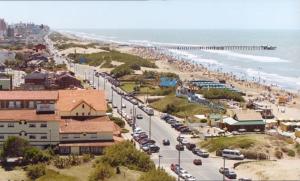 a beach with a bunch of cars parked on the sand at Hostería Mar de Ajó in Mar de Ajó