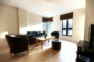 a living room with a couch and a table at Lodge Drive Serviced Apartments in Enfield