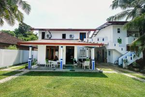 a house with a porch with chairs and a table at FEEL Villa in Kalutara +16 photos