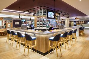 a bar in a restaurant with chairs around it at Holiday Inn London - Heathrow M4,Jct.4, an IHG Hotel in Hillingdon