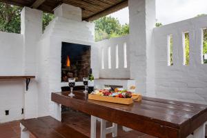 a room with a fireplace and a table with food at Ridgeworth Cottage in Greyton