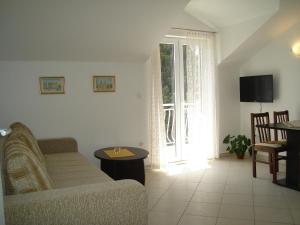 een woonkamer met een bank en een raam bij Apartments Villa Kosović in Dubrovnik