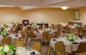 a banquet room with tables and chairs with white flowers at Holiday Inn Little Rock - Presidential Downtown by IHG in Little Rock +39 photos