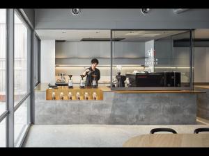 名古屋9h nine hours Nagoya station的站在玻璃墙厨房里的人