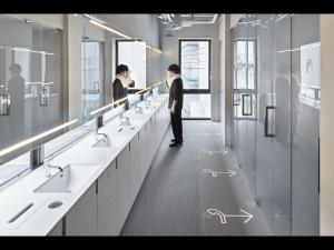 名古屋9h nine hours Nagoya station的站在带水槽和镜子的浴室中的男人 更多30张照片