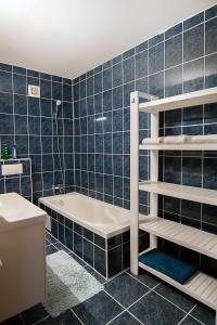 a blue tiled bathroom with a tub and a sink at Barko Residence 1 in Braşov +25 photos