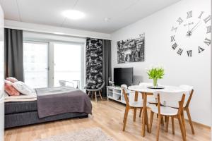 a bedroom with a bed and a table and a clock at Trendy Homes Oulu Rautatienkatu in Oulu