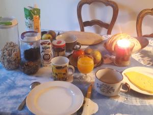 einen Tisch mit Tassen und Teller mit Speisen und Obst in der Unterkunft Chez Mimi - chambre vue parc in Brüssel