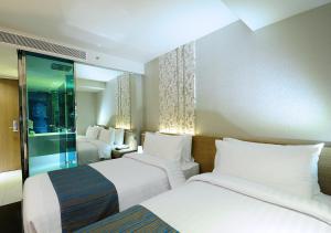 a hotel room with two beds and a window at Citrus Sukhumvit 13 Nana Bangkok by Compass Hospitality in Bangkok