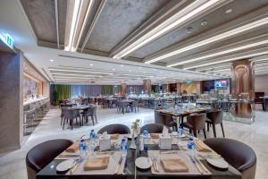 ein Restaurant mit Tischen und Stühlen in einem Raum in der Unterkunft Remal Hotel & Villas Al Dhannah City in Ruwais