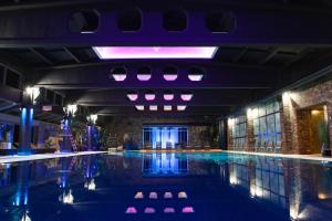 a swimming pool with blue lights in a building at Baltic Beach Hotel & SPA in Jūrmala