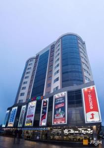 a large building with signs on the side of it at Люкс апартаменты РАЙОН АВТОВОКЗАЛА,в ЖКАрена, ПОБЛИЗУ ОБЛАСНОІ ЛІКАРНІ in Rivne