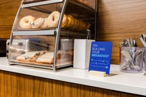 a shelf with donuts and a sign on it at Holiday Inn Express & Suites - West Edmonton-Mall Area, an IHG Hotel in Edmonton