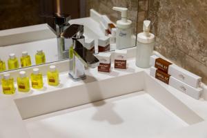 w łazience znajduje się blat z produktami na białej umywalki w obiekcie Hotel IRIS w Taszkiencie +24 zdjęcia