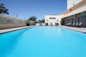 una piscina de agua azul en un edificio en Holiday Inn Los Angeles - LAX Airport, an IHG Hotel, en Los Ángeles