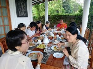 Un gruppo di persone seduti intorno a un tavolo che mangiano cibo di The European Gate - Anuradhapura a Anuradhapura