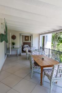 a porch with a wooden table and chairs at Apple And Spice Guest House in George