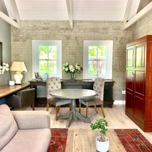 uma sala de estar com mesa e cadeiras em One Oak Guest House em Somerset West