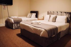a hotel room with two beds and a tv at The New Alexandra Hotel in Llandudno +43 photos