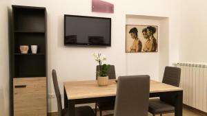 a dining room with a table and a television on the wall at EApartmentsfoligno in Foligno