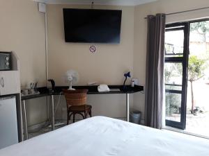 a bedroom with a television and a bed at 8 Ibis Lane Guest House in Johannesburg