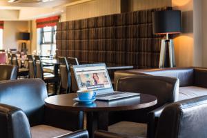 laptopa siedzącego na stole w restauracji w obiekcie Holiday Inn Express London Luton Airport, an IHG Hotel w Luton