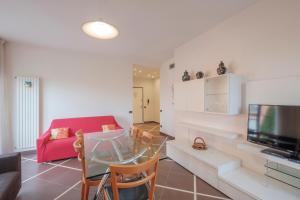 ein Wohnzimmer mit einem roten Sofa und einem Glastisch in der Unterkunft Aura Home Sirmione - 2 bedrooms apartment in Sirmione