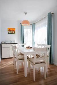 a white dining room with a white table and chairs at Barko Residence 1 in Braşov