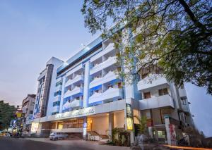 a building with a car parked in front of it at Zip by Spree Hotels Mangala International in Coimbatore