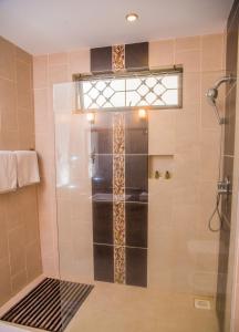 een douche met een glazen deur in de badkamer bij Nyali Beach Holiday Resort in Nyali