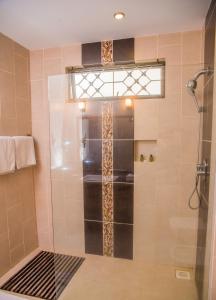 une douche avec une porte vitrée dans une salle de bain dans l'établissement Nyali Beach Holiday Resort, à Nyali
