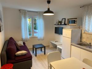 a living room with a couch and a kitchen at Holiday Home Darko in Novalja