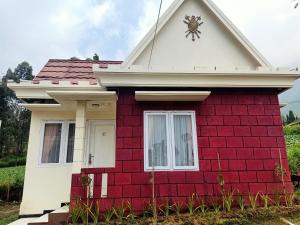 une maison rouge et blanche avec une horloge. dans l'établissement Istana Bromo Resort, à Bromo