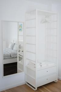 a white bedroom with a bed and a mirror at Barko Residence 1 in Braşov