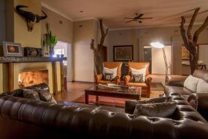 a living room with a leather couch and a fireplace at Karongwe Portfolio- Shiduli Private Game Lodge in Karongwe Game Reserve