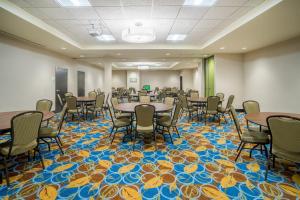 a conference room with tables and chairs on a colorful carpet at Holiday Inn - Terre Haute by IHG in Terre Haute +31 photos