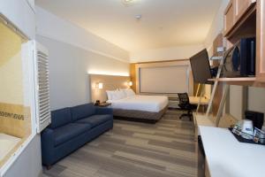 a hotel room with a bed and a couch at Holiday Inn Express Rochester Hills by IHG in Rochester Hills +23 photos