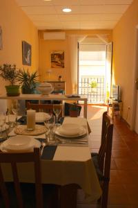 una sala da pranzo con tavolo, piatti e bicchieri di Apt ideal para familias cerca del mar a L'Ampolla