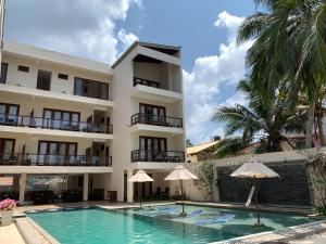 un hotel con piscina di fronte a un edificio di Sapphire Seas Beachfront Hotel a Hikkaduwa