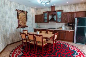 eine Küche mit einem Tisch und Stühlen auf einem Teppich in der Unterkunft Gоlden Dragon Villa Hotel in Bischkek