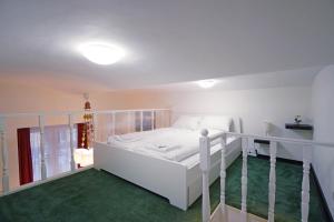sypialnia z białym łóżkiem i zielonym dywanem w obiekcie V27 Vadász Apartment w Budapeszcie