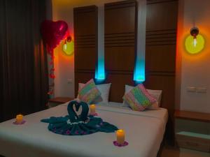 a room with a bed with two candles on it at Rimnatee Resort Trang in Trang