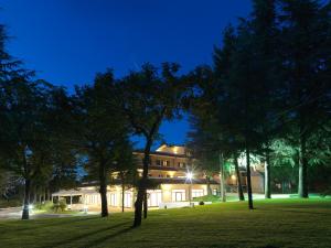 un edificio de noche con árboles en el primer plano en Il Castagneto Hotel, en Melfi