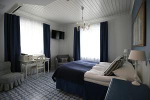 a bedroom with a bed and a desk and windows at Boutique Hotel Yöpuu in Jyväskylä