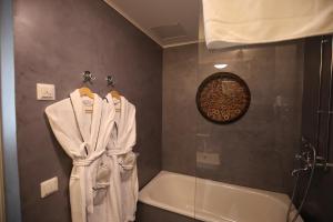 a bathroom with a shower and a bath tub with a robe at Boutique Hotel Yöpuu in Jyväskylä