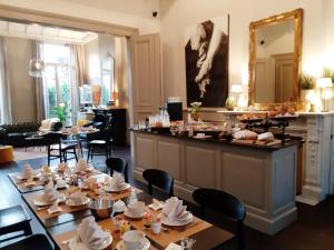 a restaurant with tables and chairs and a mirror at B&B La Corderie in Hamme