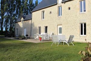 a group of chairs and a table in front of a building at La ferme de Fumichon in Tour-en-Bessin +20 photos